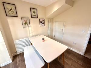 a room with a white table and a bench at Torwood Townhouse - SuperFast WiFi, Contractor Friendly with Free Parking in Edinburgh