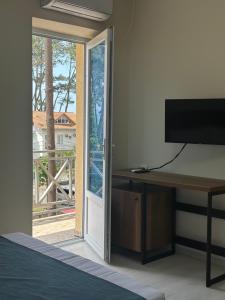 a bedroom with a desk and a sliding glass door at Hotel albatros shekvetili in Shekhvetili