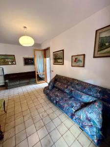 ein Wohnzimmer mit einem Sofa auf einem Fliesenboden in der Unterkunft Casa dei Ricordi in Tirrenia