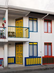 a building with yellow and blue doors on it at Casa Palma Tranquility 2 bedrooms in Salento