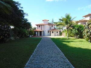 una entrada de ladrillo que conduce a una casa con un patio de césped en Casa Buzios Frente ao Mar, en Búzios