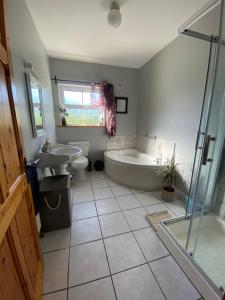 a bathroom with a tub and a toilet and a sink at The Lodge in Enniscorthy +60 photos