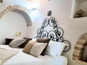 1 dormitorio con cama blanca y negra con almohadas en Panoramic Terrace, en Alberobello