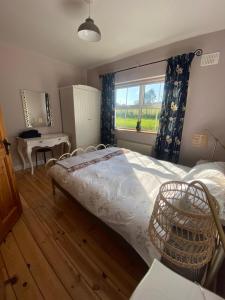 a bedroom with a bed and a desk and a window at The Lodge in Enniscorthy