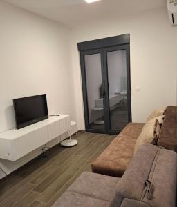 a living room with a tv and a couch at Zen Studio Apartman in Kotor +9 photos