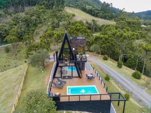 邦雷蒂鲁Chalé Encantos do Frade的享有带游泳池的房屋的空中景致