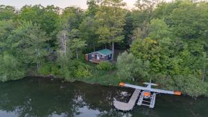 an aerial view of a house and a plane in the water at Camping Chalets Lac St-Augustin in Quebec City
