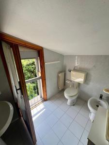 ein Badezimmer mit Toilette und Waschbecken und einem Fenster in der Unterkunft Casa dei Ricordi in Tirrenia