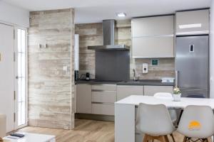 Una cocina con gabinetes blancos y una mesa y sillas blancas. en Alma gaditana en la caleta, en Cádiz 15 fotos más