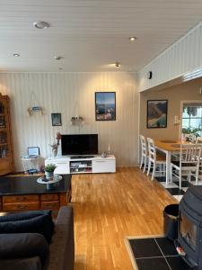 a living room with a couch and a tv and a table at Northern Dream Lofoten in Hovdan