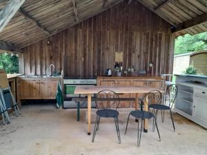 a kitchen with a table and chairs in a kitchen at Chambres en roulotte sur lieu atypique de ressourcement in Mauzac-et-Grand-Castang