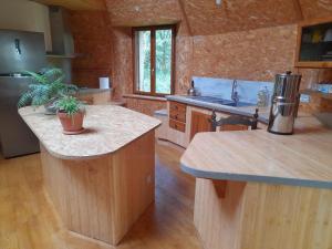 a kitchen with a island in a log cabin at Chambres en roulotte sur lieu atypique de ressourcement in Mauzac-et-Grand-Castang +2 photos