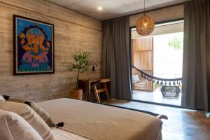 a bedroom with a bed and a painting on the wall at Jiloo Beautiful Retreat in Punta Zicatela 8 in Brisas de Zicatela