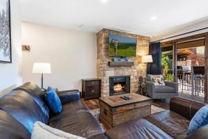 un soggiorno con divano e camino di Rooftop Hot Tub, Free Parking, Renovated condo in the Heart of Lionshead a Vail