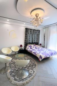 a bedroom with a bed and tables and a chandelier at Residential Apartment in Bir el Djir