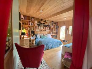 a bedroom with a bed in a room with bookshelves at L'Aquarium de Proust sous les arbres in Lacanau