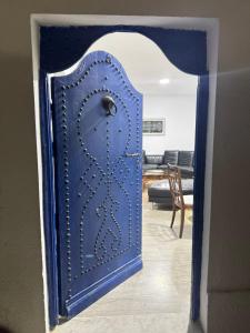 an open blue door into a living room at La Marsa Maison avec jardin, terrasse parking Wifi Illimité in La Marsa