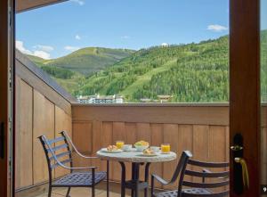 ベールにあるReduced Rates, Full Private Condo within a 5 Star Hotel, Vail Village Locationの眺めの良いバルコニーにテーブルと椅子が置かれている