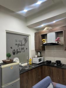a kitchen with a stainless steel refrigerator and a sink at Mountain Villa Family Guest House in Islamabad
