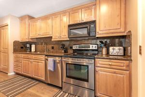 a kitchen with stainless steel appliances and wooden cabinets at Private Hot Tub and Sauna, Right on Fairway, Minutes From Vail Village & Golden Peak in Vail +41 photos