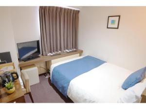 a hotel room with a bed and a television at POD SELECT HOTEL SHINJUKU - Vacation STAY 43667v in Tokyo +8 photos