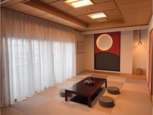 un soggiorno con tavolo e schermo di The Residence Hotel Okayama - Vacation STAY 43031v a Okayama