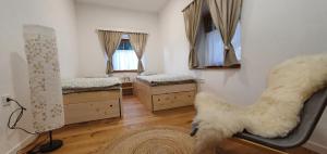 a room with two beds and a chair in it at Apartments Tourist Farm Štorman with EV Ch-Station in Tržič