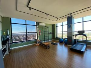 an empty room with a gym with large windows at Apartamento Sunset Residence in Dourados