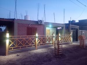 a house with a fence and lights in front of it at Complejo Cerro Morado in Villa Unión