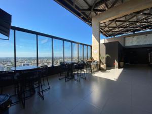 a room with tables and chairs in a building with windows at Apartamento Sunset Residence in Dourados