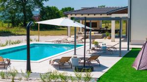 une piscine avec des chaises et un parasol à côté d'une maison dans l'établissement Villa Aria Relax Your Private Oasis in Bisko Village, à Bisko