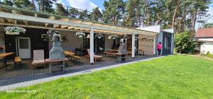 a pergola with tables and chairs in a yard at Pensjonat przy plaży in Wielen Zaobrzanski