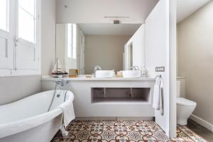 a bathroom with a tub and two sinks and a toilet at Palacio Miraflores in Santa Cruz de Tenerife