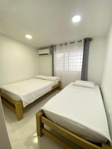 a room with two beds and a window at Blanca House in Arboletes