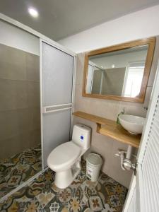 a bathroom with a toilet and a sink and a mirror at Blanca House in Arboletes +15 photos