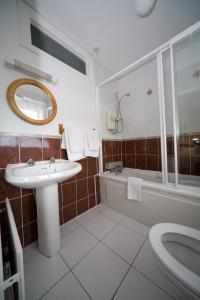 a bathroom with a sink, toilet, and bathtub at Danabel B&B in Kinsale