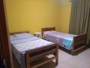 two beds in a room with yellow walls at Casa en Amaicha in Amaicha del Valle