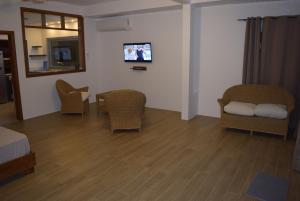 a room with wicker chairs and a tv on the wall at Mountain View Studio in La Gaulette