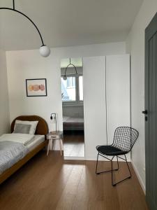 a bedroom with a bed and a chair in it at Dębina Lounge 20 Apartamenty in Debina