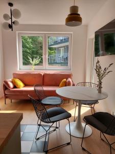 a living room with a couch and a table and chairs at Dębina Lounge 20 Apartamenty in Debina