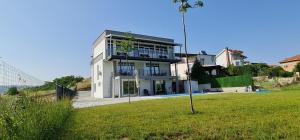 a large white house with a lawn in front of it at Tashev Apartments in Veles