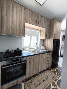 a kitchen with wooden cabinets and a sink and a window at MAGIA's HOUSE in Karistos