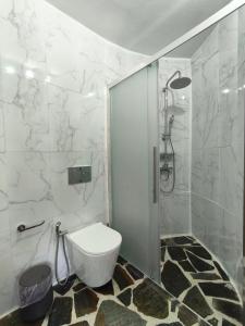 a white bathroom with a toilet and a shower at MAGIA's HOUSE in Karistos