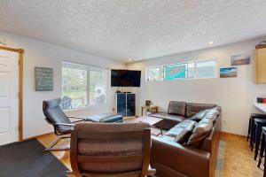 a living room with a leather couch and chairs at Cozy Cove in Manzanita