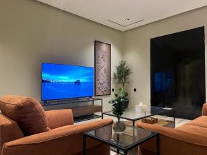 Una sala de estar con dos sofás y un televisor de pantalla plana. en سويت بغرفة نوم وصالة جانبية, en Hail