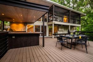 an outdoor deck with a bar and a house at TreeTops Spacious Architectural Retreat in Gainesville
