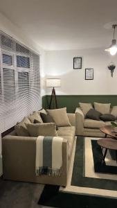 a living room with a couch and a table at Cozy and Stylish stays at Maiden Lane in Ifield +97 photos