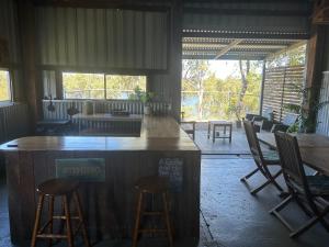 a bar in a room with chairs and tables at Waterview Cottage in Baffle Creek