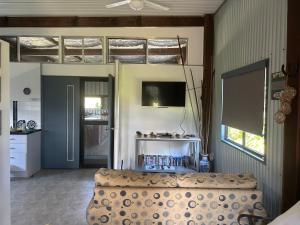 a living room with a couch and a tv at Waterview Cottage in Baffle Creek