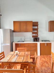 a kitchen with a wooden table and a refrigerator at Kambal Peregrino in Mérida